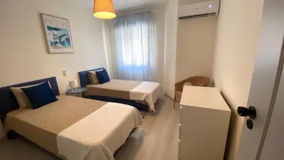 a hotel room with two beds and a window at Lusitania T2 Frente Mar em Quarteira in Quarteira