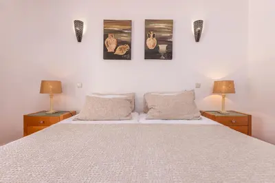 a bedroom with a white bed with two lamps at Villa Ericeira by OCvillas in Albufeira