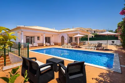 a villa with a swimming pool and a house at Villa Ericeira by OCvillas in Albufeira
