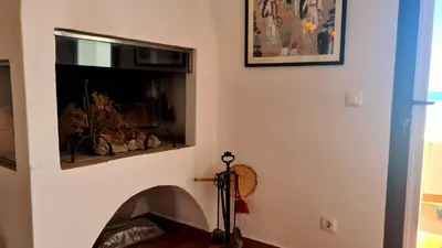 a living room with a fireplace and a tripod at Albufeira Beach Cliffs House in Albufeira