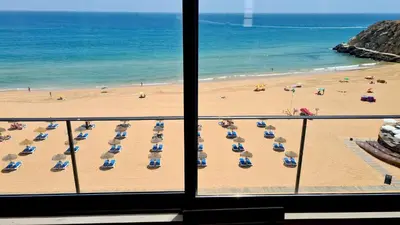 a view of a beach with chairs and umbrellas at Albufeira Beach Cliffs House in Albufeira