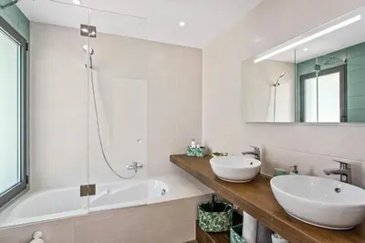 a bathroom with two sinks and a tub and a mirror at Villa Ohana in Albufeira