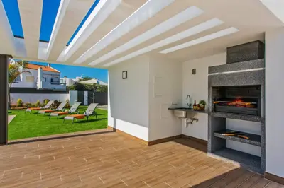 a living room with a fireplace and a patio at Villa Ohana in Albufeira