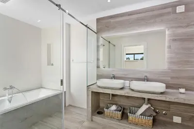 a bathroom with two sinks and a tub and a mirror at Villa Ohana in Albufeira