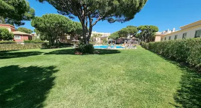 a large yard with a swimming pool and trees at Apartamentos Praia da Oura by Sunny Deluxe in Albufeira