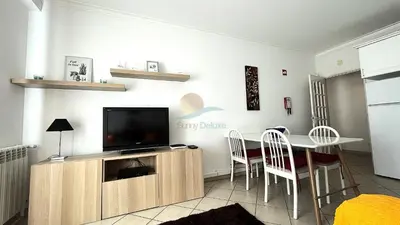 a living room with a tv and a table and chairs at Apartamentos Praia da Oura by Sunny Deluxe in Albufeira