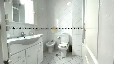 a white bathroom with a sink and a toilet at Apartamentos Praia da Oura by Sunny Deluxe in Albufeira