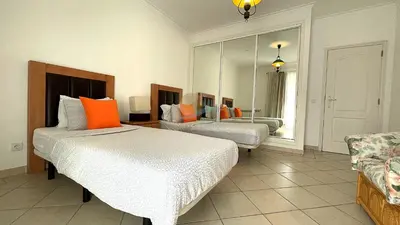 a hotel room with two beds and a mirror at Apartamentos Praia da Oura by Sunny Deluxe in Albufeira