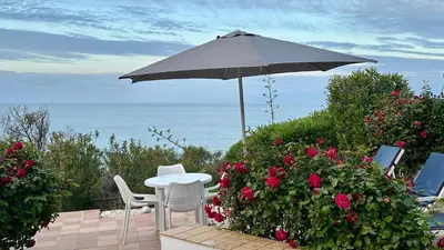 a table and chairs under an umbrella next to flowers at Beira Mar by Check-in Portugal in Albufeira