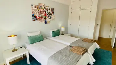 two beds in a room with a painting on the wall at Rooftop by Check-in Portugal in Albufeira