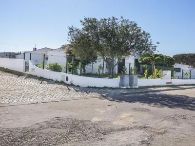 a white fence with a tree in front of a building at Villa Villa Jacaranda V3 by Interhome in Albufeira