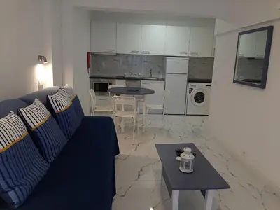 a living room with a blue couch and a table at Quarteira SeaSide in Quarteira