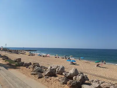 a group of people on a beach near the ocean at Quarteira SeaSide in Quarteira