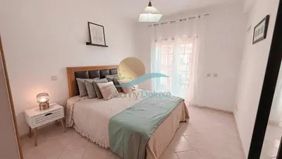 a bedroom with a bed and a table and a window at Kamaleon Sol by Sunny Deluxe in Albufeira