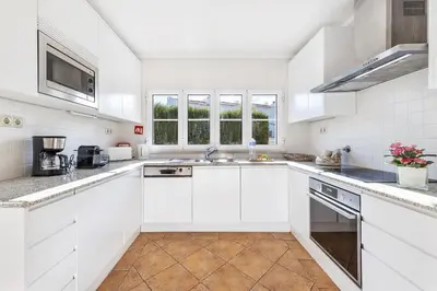 a white kitchen with white cabinets and a sink at Villa Dome by OCvillas in Albufeira