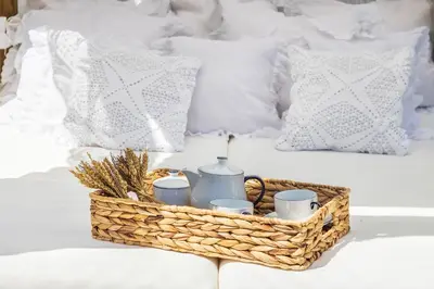 a wicker basket on a bed with mugs and candles at Villa Dome by OCvillas in Albufeira