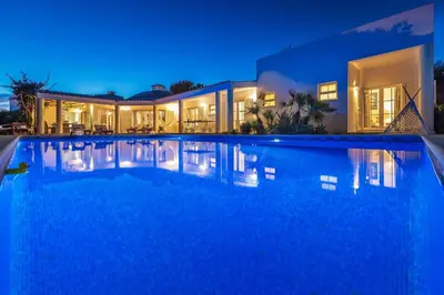 a large swimming pool in front of a house at night at Villa Dome by OCvillas in Albufeira