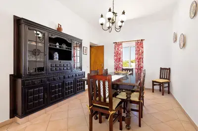 a dining room with a table and a large cabinet at Casa da Bia by OCvillas in Albufeira