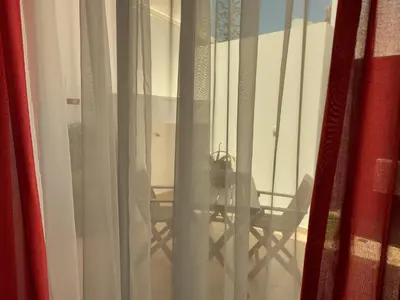 a dining room table and chairs seen through a window at Casa Flor de Sal - moradia no Centro de Faro! in Faro