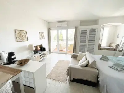 a white room with a bed and a couch at Seaview Studio - 10 Min. Beach, Private Condo, Pool, Grill & Free Parking in Albufeira