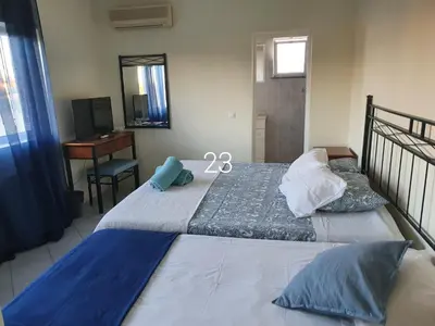 a bedroom with a bed and a desk and a mirror at Hospedaria do Almargem in Quarteira