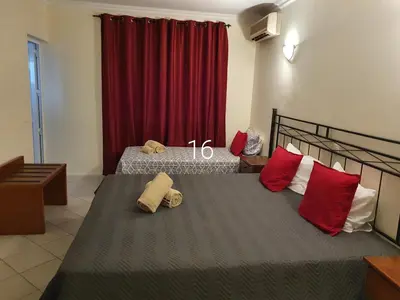 a bedroom with two beds with red pillows at Hospedaria do Almargem in Quarteira