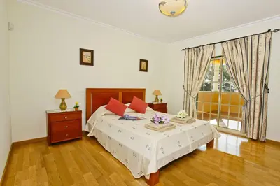 a bedroom with a large bed and a window at Villa João Paulo in Albufeira