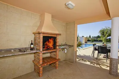 a fireplace in a living room with a patio at Villa João Paulo in Albufeira