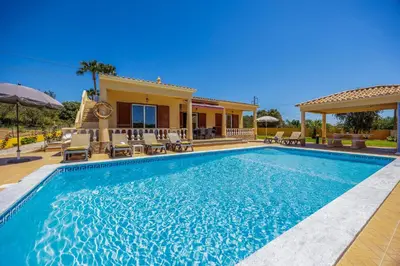 a swimming pool in front of a house at Villa Monte Velho in Albufeira