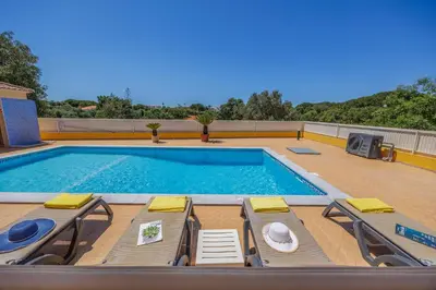 a swimming pool with lounge chairs and a swimming pool at Villa Monte Velho in Albufeira
