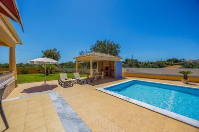 a swimming pool in a backyard with a gazebo at Villa Monte Velho in Albufeira