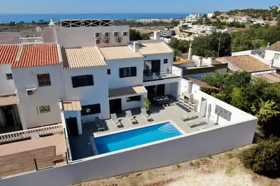 a building with a car parked in front of a street at Villa Tropicana in Albufeira