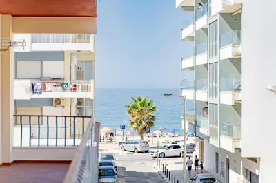 a view of the beach from the balcony of a building at AL - Apartamento Egas Moniz in Quarteira