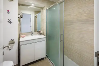 a bathroom with a shower and a sink and a mirror at AlbufeiraMar Apartment in Albufeira