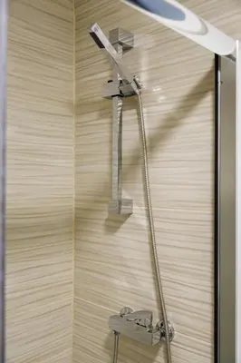 a shower with a shower head on a wooden wall at AlbufeiraMar Apartment in Albufeira