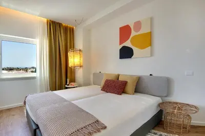a white bedroom with a bed and a window at Apartamento Boavista - Sea View by DreamvillasAlbufeira in Albufeira