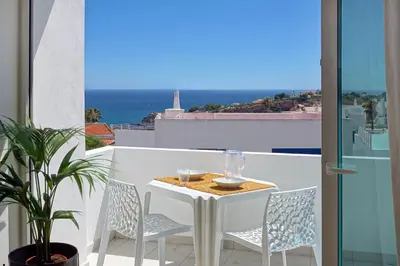 a table and chairs on a balcony with a view of the ocean at Apartamento Boavista - Sea View by DreamvillasAlbufeira in Albufeira