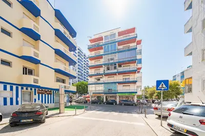 a city street with cars parked in front of buildings at AL - Apartamento Vidal Mar in Quarteira