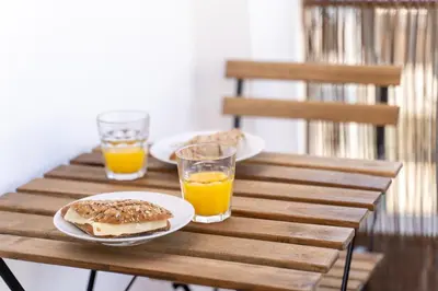 a table with two plates of food and orange juice at AL - Apartamento Vidal Mar in Quarteira
