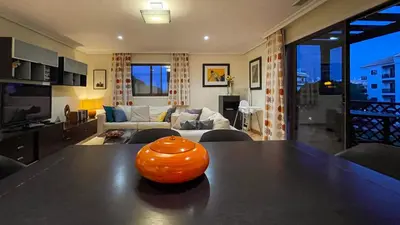 an orange vase sitting on a table in a living room at T2 Apartment Falesia Beach Albufeira in Roja- Pé