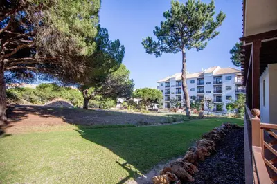 a view of a yard with a building and trees at T2 Apartment Falesia Beach Albufeira in Roja- Pé