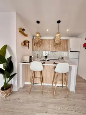 a kitchen with two white stools and a counter at White Sand Apartments Downtown Albufeira in Albufeira