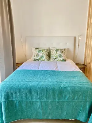 a bed with a blue blanket on top of it at White Sand Apartments Downtown Albufeira in Albufeira