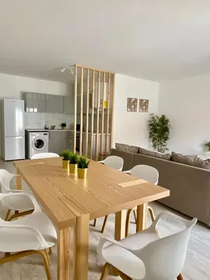 a kitchen and dining room with a wooden table and chairs at White Sand Apartments Downtown Albufeira in Albufeira