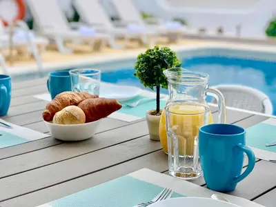 a table with a bowl of bread and a glass of juice at Villa Cristina 9 in Albufeira