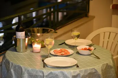 a table with a bottle of wine and a plate of food at Sandy Beach apartment in Albufeira