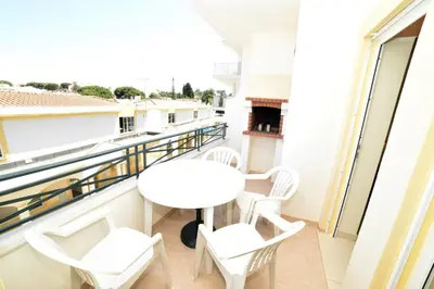 a balcony with a white table and chairs at Sandy Beach apartment in Albufeira