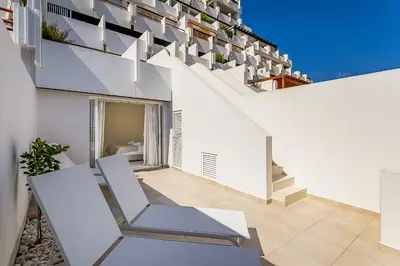 a white house with stairs and a chair at Vista dos Seus Sonhos T2 HsR Vilamarina in Vilamoura