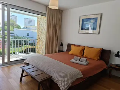 a bedroom with a large bed and a balcony at Villa Ray Design in Albufeira