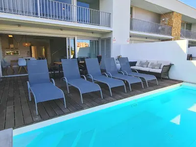 a patio with chairs and a swimming pool at Villa Ray Design in Albufeira